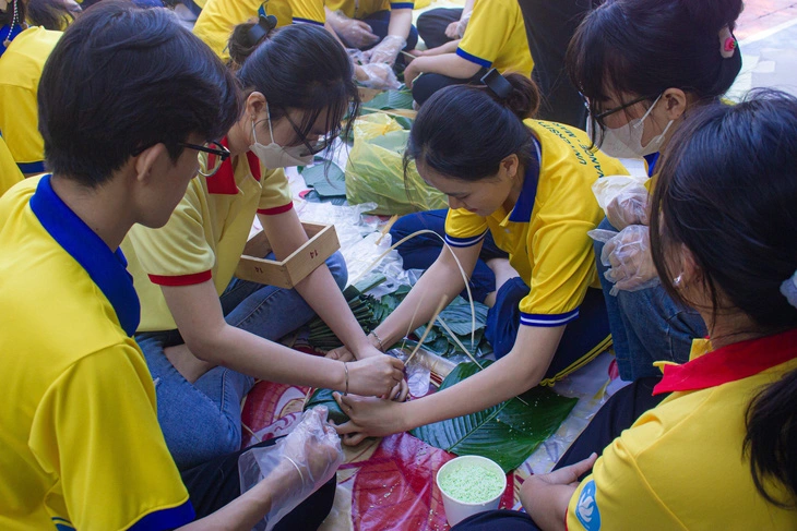 Sinh viên Trường đại học Tài chính - Marketing gói gần 500 cái bánh chưng tặng sinh viên khó khăn, cô chú bảo vệ, lao công, người dân khó khăn trên địa bàn phường Cầu Ông Lãnh (quận 1) và quận Tân Bình - Ảnh: UFM